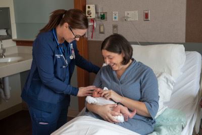 Doctor checking on mom and baby